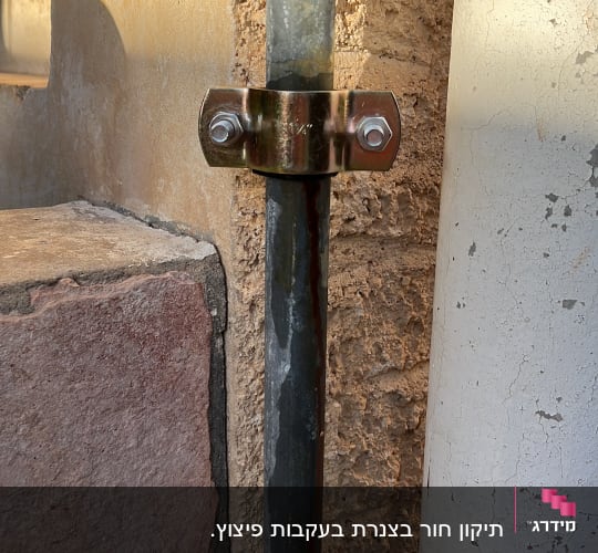 צינור מתכת עם תושבת ברגים על קיר